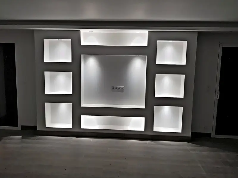 Meuble mural TV avec niches éclairées par spots encastrés et prises intégrées
